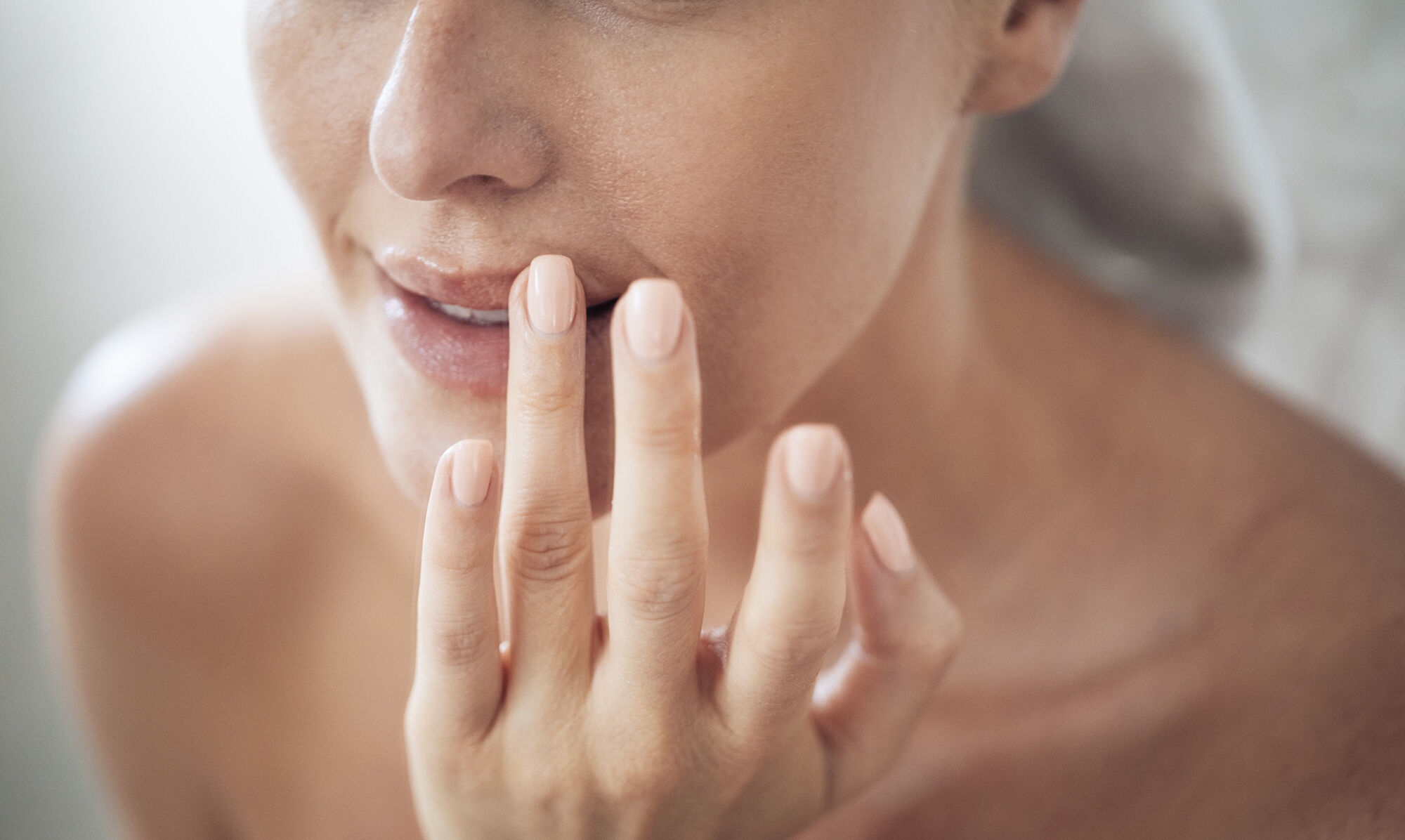 frau mit fingern an den lippen