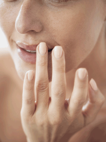 frau mit fingern an den lippen