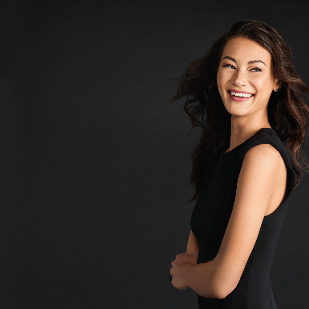 Frau mit strahlendem Lächeln – Selbstvertrauen durch ästhetische Behandlungen